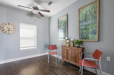 Brightly decorated interior room with two chairs and artwork