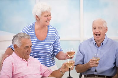 Seniors toasting with drinks in a cheerful setting