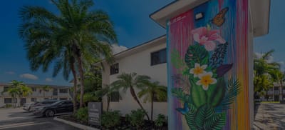 Exterior view of Plaza Gardenia Apartments with vibrant mural
