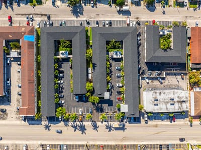 Aerial view of Plaza Gardenia Apartments with surrounding parking