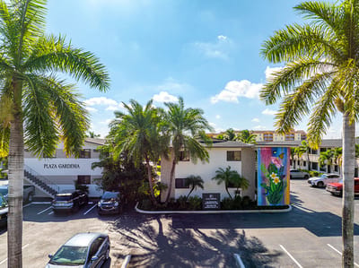 Exterior view of Plaza Gardenia Apartments with palm trees