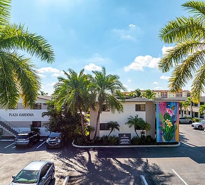 Exterior view of Plaza Gardenia Apartments with palm trees