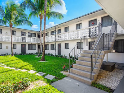 Courtyard view of Plaza Gardenia Apartments with palm trees