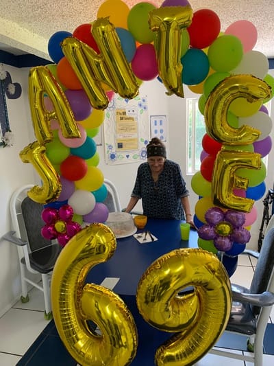 Resident celebrating a milestone inside a decorated area