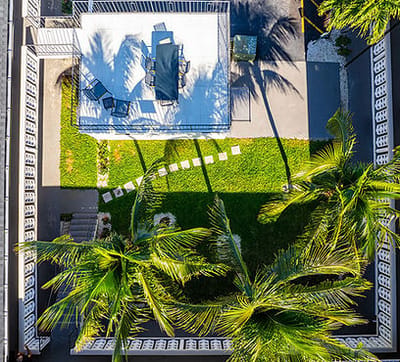 Aerial view of a landscaped outdoor space with seating and palm trees