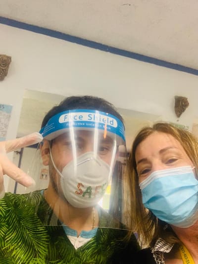 Staff member and resident posing together with masks