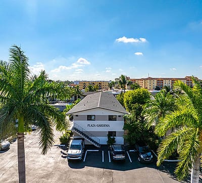 Exterior view of Plaza Gardenia Apartments with palm trees