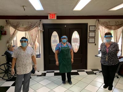 Staff members wearing PPE in a facility interior