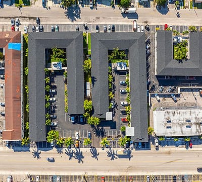 Aerial view of Plaza Gardenia Apartments with parking and landscaping