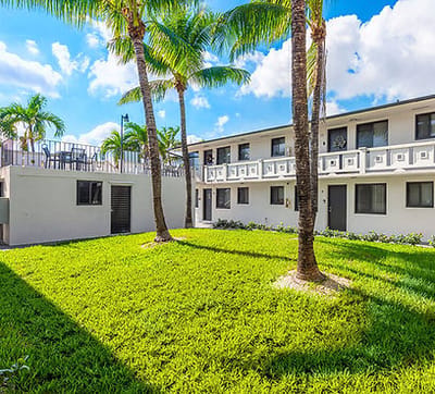 Exterior view of Plaza Gardenia Apartments with landscaping