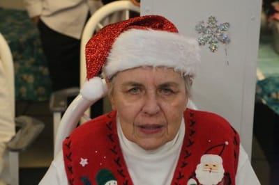 Resident in a festive holiday sweater and Santa hat