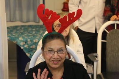 Resident wearing festive reindeer antlers and smiling