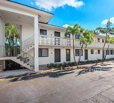 Exterior view of Plaza Gardenia Apartments with tropical plants
