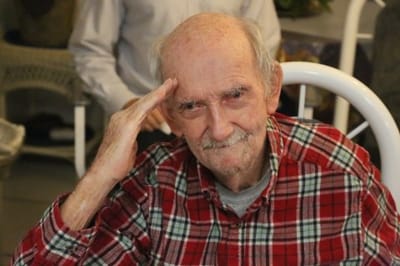 An elderly man smiling in a residential space