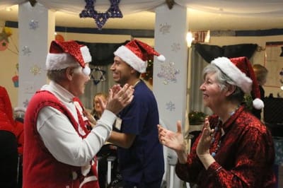 Residents and staff celebrating with holiday hats