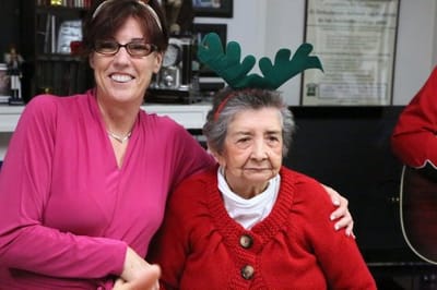 Staff member with a resident in holiday attire
