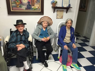 Three residents seated in a common area.