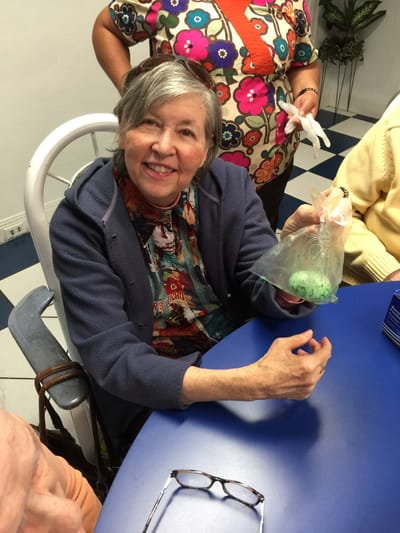 Resident smiling and participating in an activity at a table