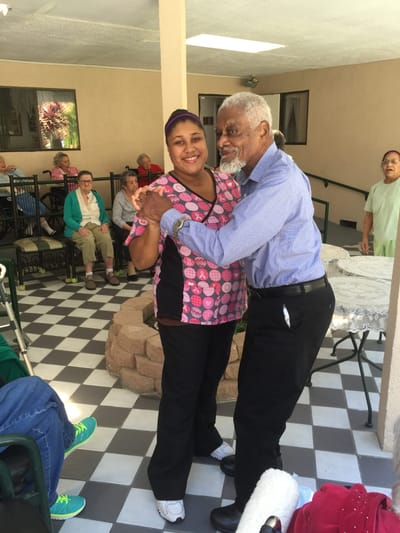 Resident dancing with staff member in common area