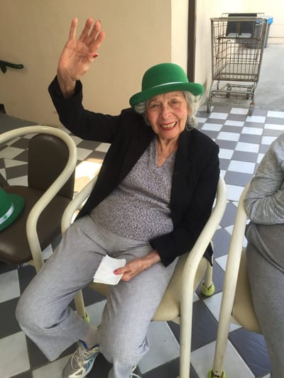 Resident waving and smiling while seated