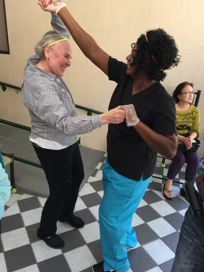 Staff dancing with a resident during an activity