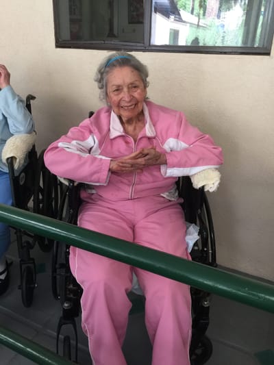 A smiling resident in a wheelchair in the facility