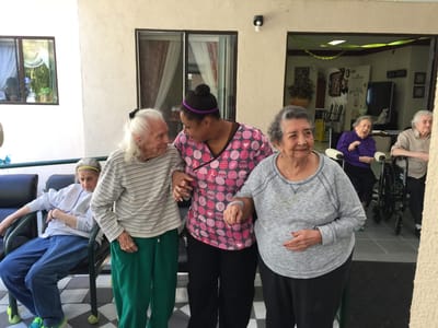 Residents enjoying time outdoors with staff assistance