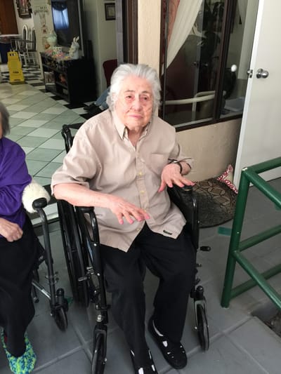 Elderly resident sitting in a wheelchair in a facility