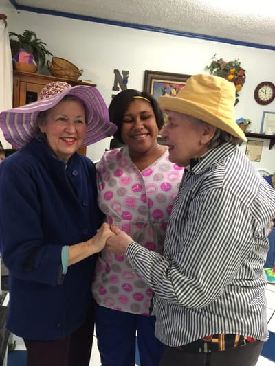 Staff interacting with residents in cheerful hats