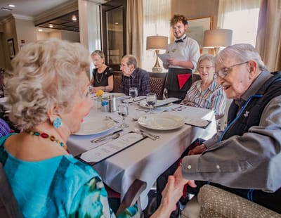 Residents enjoying a meal together in the dining room.