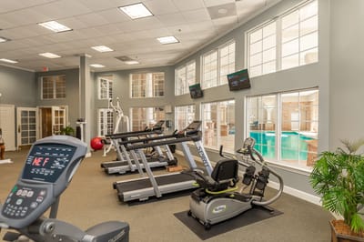 Indoor gym with exercise equipment and large windows