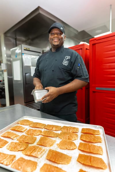 Chef preparing salmon in the kitchen.