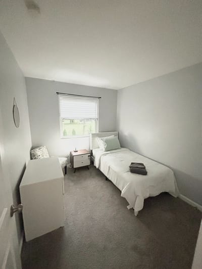 Cozy private resident room with a bed and chair