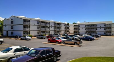 Exterior view of Birchwood Manor Senior Apartments with parked cars