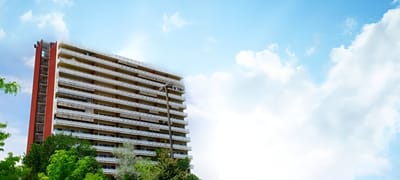Exterior view of a senior living facility surrounded by trees