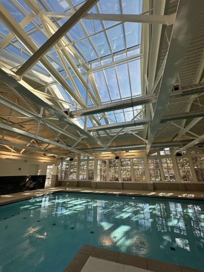 Indoor swimming pool with high ceiling and natural light