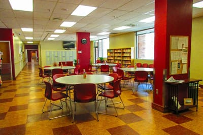 Common area with round tables and red chairs