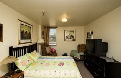 A cozy resident room with a bed and seating area
