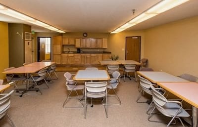 Bright common area with tables and chairs for activities.