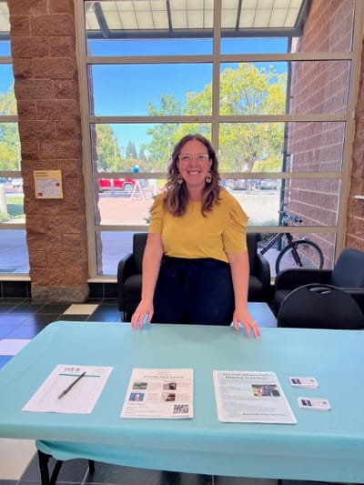 Staff member at a table with information materials
