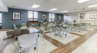 Bright dining room with tables and chairs set up