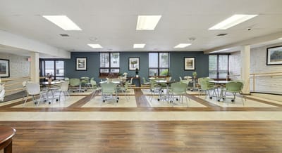 Common area with tables and chairs in a senior living facility