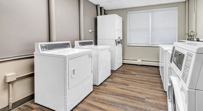 Laundry room with multiple washing machines and dryers.