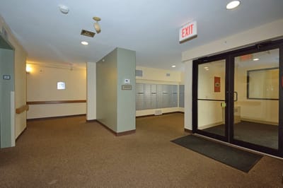 Empty interior hallway with mailboxes and exit sign
