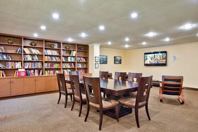 Common area with a large table and bookshelf.