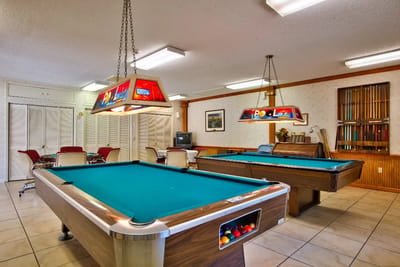 Interior game room with billiard tables and seating