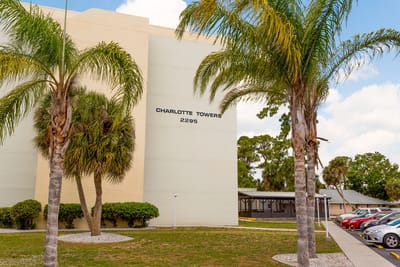 Exterior view of Charlotte Towers with palm trees.