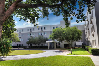 Exterior view of Presbyterian Towers with landscaped area.