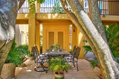 Outdoor patio dining area surrounded by greenery.