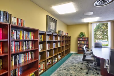 Interior view of a library with bookshelves and meeting table.